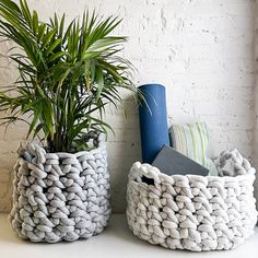 two knitted baskets sitting next to each other on top of a white countertop