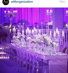 a long table is set up with clear chairs and candles for an elegant wedding reception