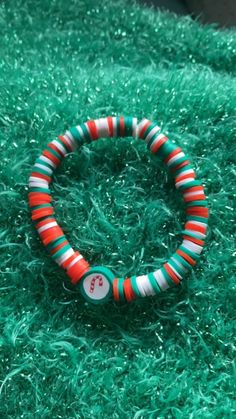 This is a red white and green bracelet.  It also has a Christmas charm. Green Christmas Gift Bracelets, Green Bracelets For Christmas Gift, Green Christmas Bracelet Gift, Green Christmas Festive Bracelets, Christmas Gift Green Bracelet, Red Christmas Bracelets For The Holidays, Red Christmas Bracelets For Holiday, Red Christmas Bracelet For Holiday, Red Christmas Holiday Bracelet