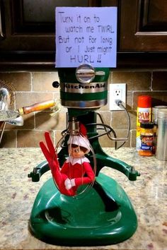 an elf on top of a green machine with a sign above it that says turn it on to watch me twin but not for long or just more