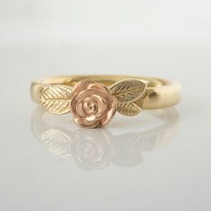 a gold rose ring with leaves on it