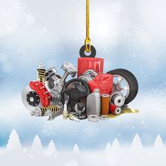 a pile of assorted motor parts hanging from a yellow hook on a snow covered background