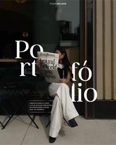 a woman sitting on top of a chair while reading a newspaper in front of a building