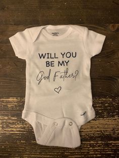 a white bodysuit with the words will you be my god father? on it