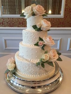 a three tiered wedding cake with flowers on top