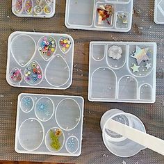 several plastic trays filled with different types of crafting supplies on top of a wooden table