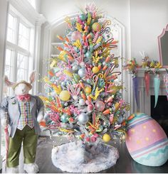 a decorated christmas tree in the middle of a living room with an easter bunny standing next to it