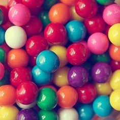 there are many different colored candy balls in the bowl