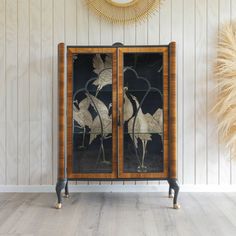 an art deco cabinet with two birds on it