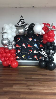 a balloon arch with black, white and red balloons