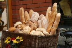 a basket filled with lots of bread next to a bike parked in front of a building