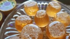 some ice cubes sitting on top of a glass bowl filled with water and orange juice