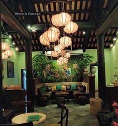 a living room filled with furniture and lots of lights hanging from the ceiling above it