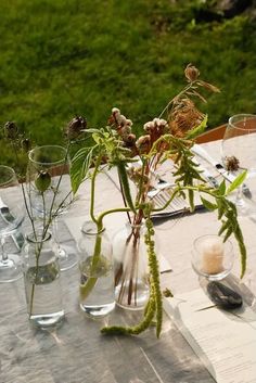 there are many vases with flowers in them on the table