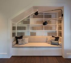 a white couch sitting under a book shelf filled with books