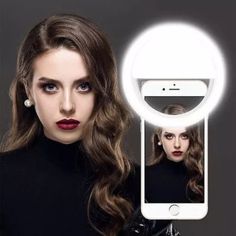 a woman holding up a cell phone with a selfie camera attached to her face