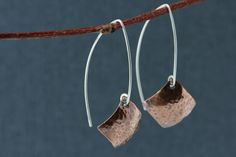 Hand formed sterling silver open hoops in an almond shape with dangling hammered copper squares, in a diamond shape. These light weight copper earrings have a light patina that brings out an earthy warm quality. Modern and a bit rustic! These earring are 1 3/4 inches (4.5 cm) long in the front, the back hangs a bit longer. The copper square is 5/8 x 5/8 inches (16 mm) All earrings come with clear earring stoppers. All of my designs are created by me, including all the metal components like ear w Handmade Modern Copper Jewelry, Modern Handmade Copper Jewelry, Minimalist Hammered Copper Jewelry, Hoop Silver Earrings, Simple Silver Earrings, Hammered Copper Earrings, Clear Earrings, Hammered Earrings, Earrings Diamond