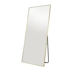 a mirror that is standing up against a white wall with a black stand on it