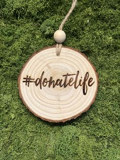 a wooden sign with the word donatie on it hanging from a string in grass