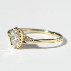 a yellow gold engagement ring with an oval cut diamond