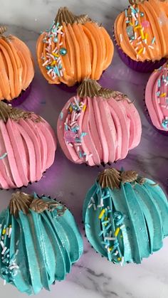 cupcakes decorated with frosting and sprinkles on a marble surface