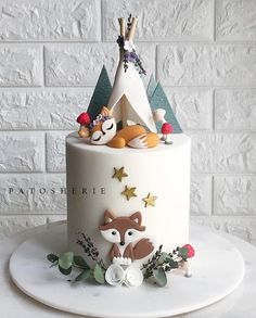 a white cake decorated with woodland animals and stars