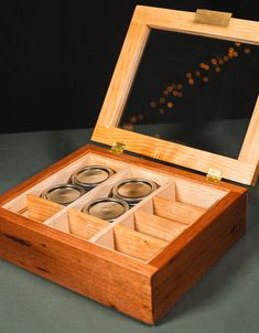 an open wooden box with four rings inside