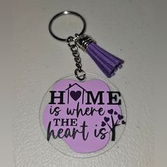 a purple keychain with the words home is where the heart is on it