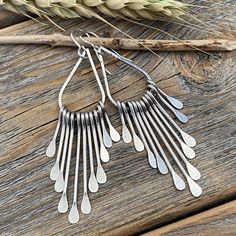 Silver Teardrop Boho Fan Earrings: These silver fan paddle earrings are the perfect mix of geometric & boho and will compliment any outfit! Graduated hammered paddles hang from a beautifully crafted teardrop focal point. These earrings are handcrafted from silver plated jewelers grade brass. They are approximately 2.75 inches in length and .62 inches at the widest portion. To view more of my original jewelry designs, visit: https://www.etsy.com/shop/TheBeadCounter Bohemian Teardrop Sterling Silver Chandelier Earrings, Bohemian Sterling Silver Teardrop Chandelier Earrings, Modern Silver Teardrop Chandelier Earrings, Bohemian Teardrop Earrings Nickel Free For Everyday, Silver Bohemian Teardrop Dangle Earrings, Bohemian Long Drop Teardrop Earrings, Bohemian Teardrop Long Drop Earrings, Silver Teardrop Chandelier Earrings With Ear Wire, Silver Teardrop Chandelier Earrings