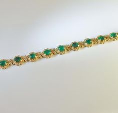 An opulent estate mint condition circa 1980 fine emerald and diamond bracelet in solid 14K yellow gold. This divine high carat luxurious bracelet is of exceptional quality. The gorgeous design of this sinuous bracelet has alternating links each set with a large faceted emerald followed by a fine cabochon emerald each precious colored gem entirely surrounded by a border of fine white diamonds. The secure box clasp is hidden inside a diamond set link. This makes the bracelet look like an endless p Fine Jewelry Bracelet With Cabochon, Formal Emerald Gemstone Bracelets, Elegant Green Cabochon Bracelets, Formal Green Cabochon Bracelets, Formal Green Cabochon Bracelet, Green Cabochon Bracelets For Formal Occasions, Green Cabochon Bracelet For Formal Occasions, Elegant Cabochon Bracelets For Anniversary, Formal 14k Gold Bracelet With May Birthstone