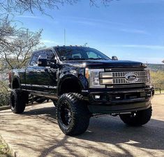 a large black truck parked on the side of a road