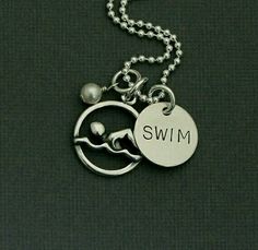 a silver necklace with the word swim on it