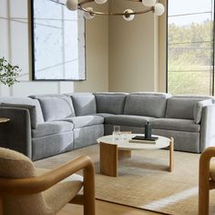 a living room filled with furniture next to a large window and a painting on the wall