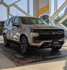 a silver chevrolet suv is on display at the showroom