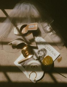 the contents of a woman's purse sitting on top of a floor next to a pair of scissors