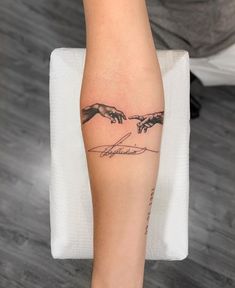 a woman's arm with the creation of hands tattooed on it