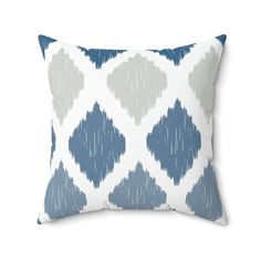 a blue and white pillow with hearts drawn on the front, against a white background