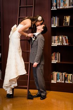 a bride and groom kissing in front of a ladder