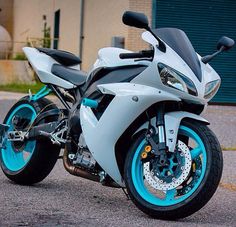 a white and blue motorcycle parked in front of a building