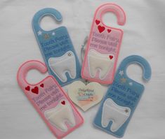 four tooth shaped baby bibs with hearts on them