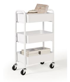 a white cart with two drawers and a magazine rack on it's wheels is shown in front of a white background