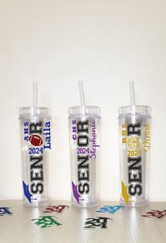 three tumblers sitting on top of a table next to each other with straws in them