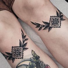 two people with tattoos on their legs sitting next to each other