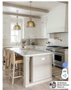 an image of a kitchen setting with white cabinets and gold pendant lights over the island