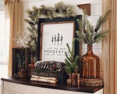 a mantle with pine cones, evergreens and other holiday decorations