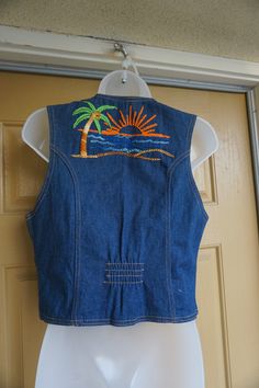 "Vintage embroidered denim vest. In good vintage condition!!. No size labeled but looks to be a small/medium. Please check measurements to ensure fit. measurements taken across front laid flat 19\" across front armpit to armpit 16.5\" across front of waist 20\" length top of shoulder to bottom" Retro Fitted Denim Jacket For Summer, Embroidered Blue Denim Vest For Summer, Vintage Sleeveless Denim Jacket For Summer, Summer Embroidered Blue Denim Vest, Blue Embroidered Denim Vest For Summer, Fitted Bohemian Denim Vest In Medium Wash, Summer Vintage Sleeveless Denim Jacket, Fitted Embroidered Denim Vest Casual, Casual Embroidered Fitted Denim Vest