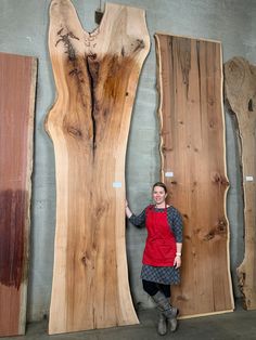 a woman standing next to two large wooden slabs