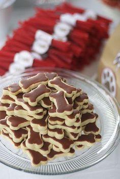 a plate full of cookies on a table with red and white desserts in the background