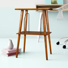 a wooden desk with two shelves on each side and a white vase next to it