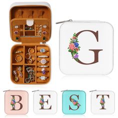 an open jewelry box with rings and bracelets in it on a white surface next to the letter g